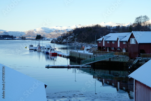 Kleiner Hafen mit rotem Haus im Winter auf den Vesteralen, Norwegen, Meer, Berg, Schnee photo