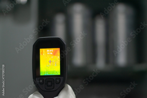 Professional Electrician use thermal infrared camera or thermometer scanning electrical system for preventive maintenance,Industrial thermography,Thermal image of power electric. photo