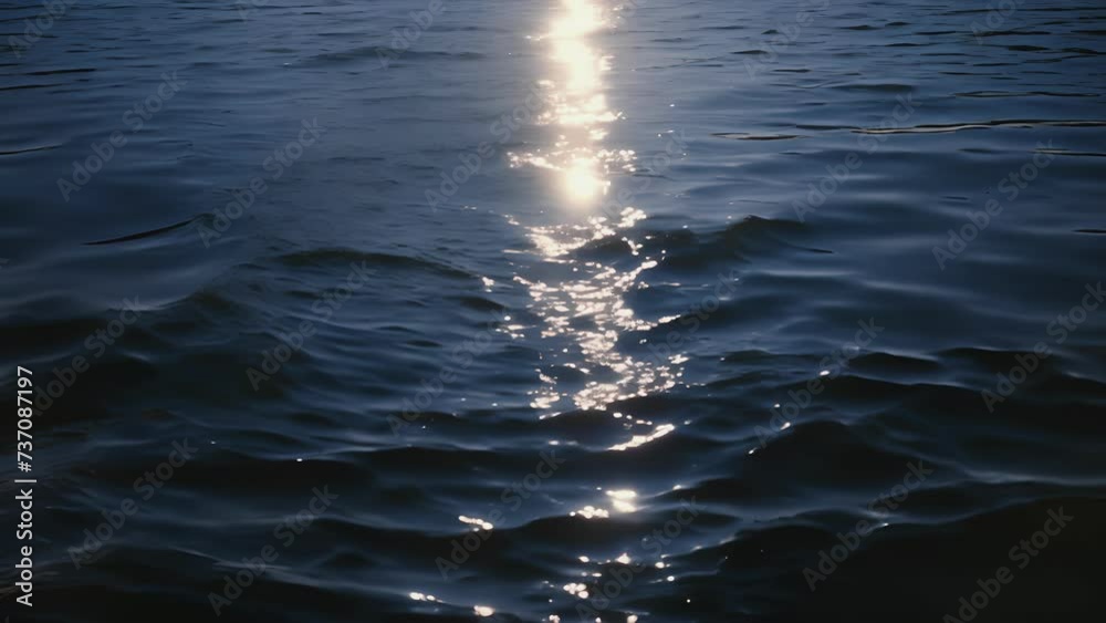 The suns reflection on the water creates a striking contrast against the deep blue of the sky in the early morning or late evening.