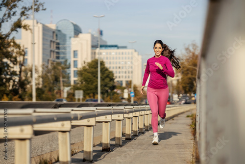 A fast city runner is running over the bridge.