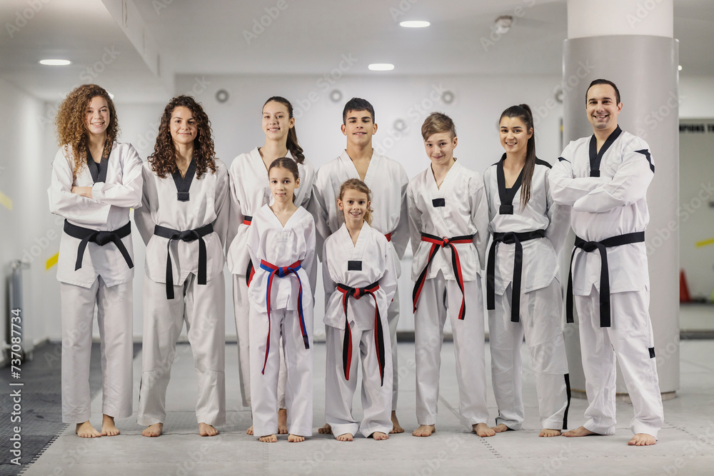 Team of taekwondo athletes standing confidently at martial art school and smiling at the camera. Team of taekwondo athletes standing confidently at martial art school and smiling at the camera.