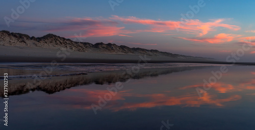 Sunset landscape of the Viago beach in Pedrogao, Figueira da Foz, Portugal, with the clouds reflected on the water. photo