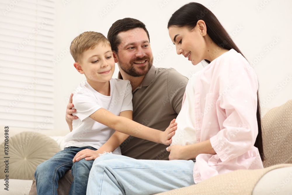 Happy pregnant woman spending time with her son and husband at home Happy pregnant woman spending time with her son and husband at home