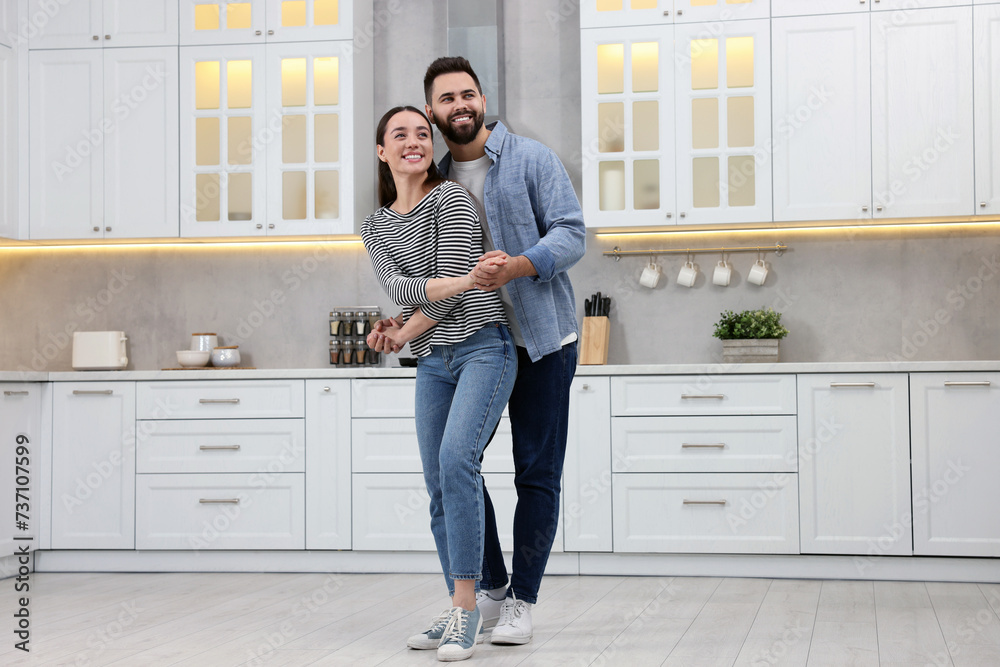Happy lovely couple dancing together in kitchen Happy lovely couple dancing together in kitchen