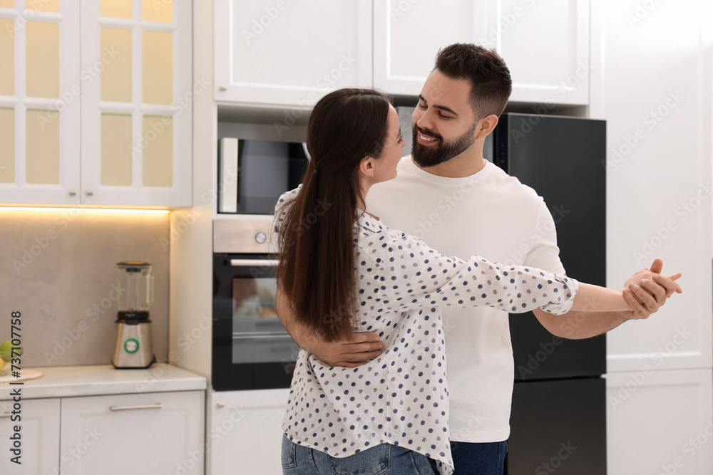 Happy lovely couple dancing together in kitchen Happy lovely couple dancing together in kitchen