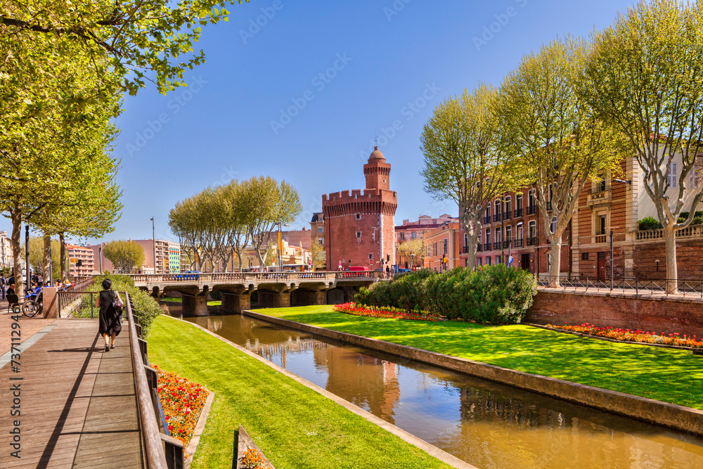 La Basse, a tributary of the Tet, which crosses the French city of Perpignan, Languedoc-Roussillon,  and the Porte du Notre Dame. - obrazy, fototapety, plakaty 