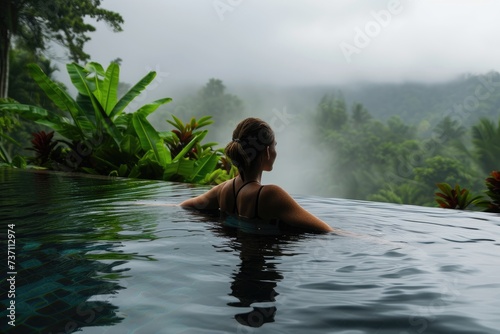 Tropical Serenity: Young Woman Enjoying Resort Pool Amidst Mountain Forests © Murda