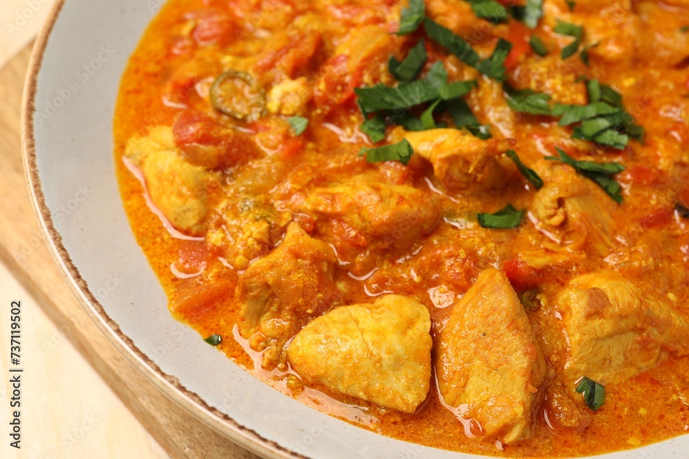 Delicious chicken curry with parsley on table, closeup