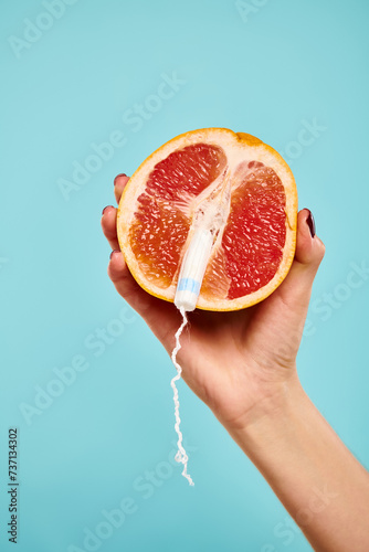 Fotografía object photo of fresh juicy grapefruit with tampon in it in hand of unknown woma