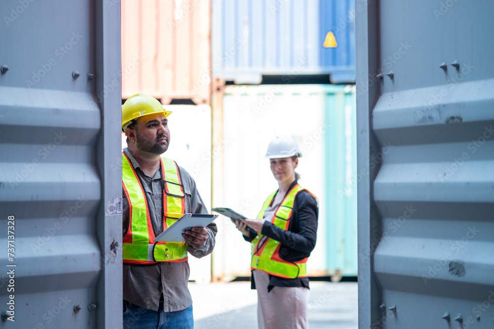 Warehouse engineer inspects the inside of a container with a customer at an industrial container yard. Warehouse engineer inspects the inside of a container with a customer at an industrial container yard.