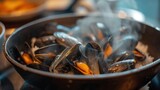 a pan filled with mussels sitting on top of a stove top next to a bowl of broth.