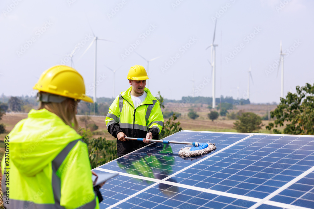 engineers examining solar panel using digital taplet computer in solar farm. solar panel cleaning officer background. engineers examining solar panel using digital taplet computer in solar farm. solar panel cleaning officer background.