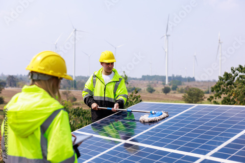 Wallpaper Mural engineers examining solar panel using digital taplet computer in solar farm. solar panel cleaning officer background. Torontodigital.ca