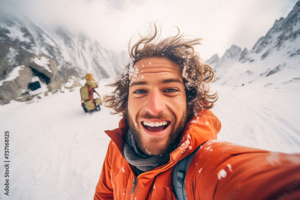 Young happy man taking selfie on a snowy mountain