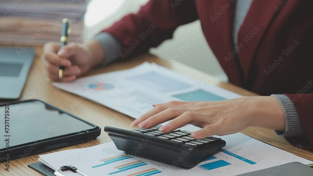 Asian Businesswoman Using laptop computer and working at office with calculator document on desk, doing planning analyzing the financial report, business plan investment, finance analysis concept. Asian Businesswoman Using laptop computer and working at office with calculator document on desk, doing planning analyzing the financial report, business plan investment, finance analysis concept.