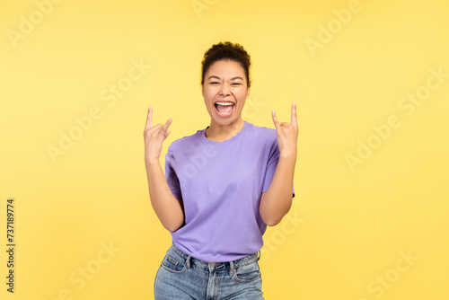Smiling, excited African American woman showing rock n roll sign, fooling around