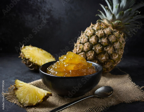 pineapple jam in a black bowl on eco fabric, product photography, food, restaurant, macro, black background photo