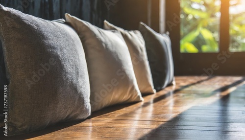 closeup upholstery pillow soft and comfort cushion line of decorating pillow on wooden floor with sun light bright and shade home inerior design design house element background photo