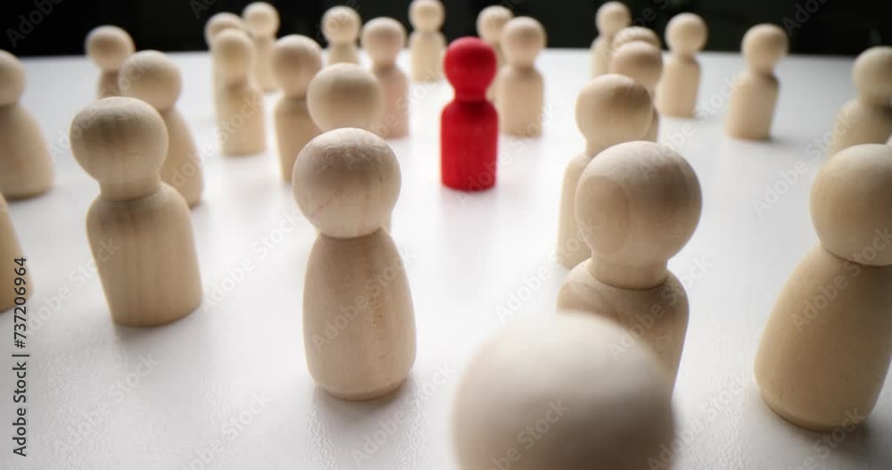 Red figurine of person in crowd of identical people. Stranger who attracts attention and special people Red figurine of person in crowd of identical people. Stranger who attracts attention and special people