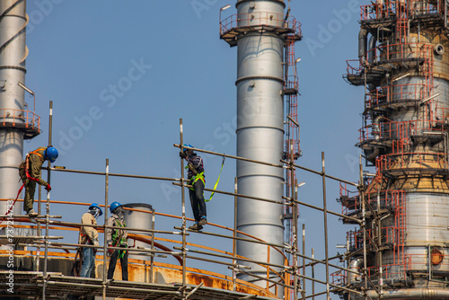Construction workers installing scaffolding storage tank Oil​ refinery​ and​ plant and tower column