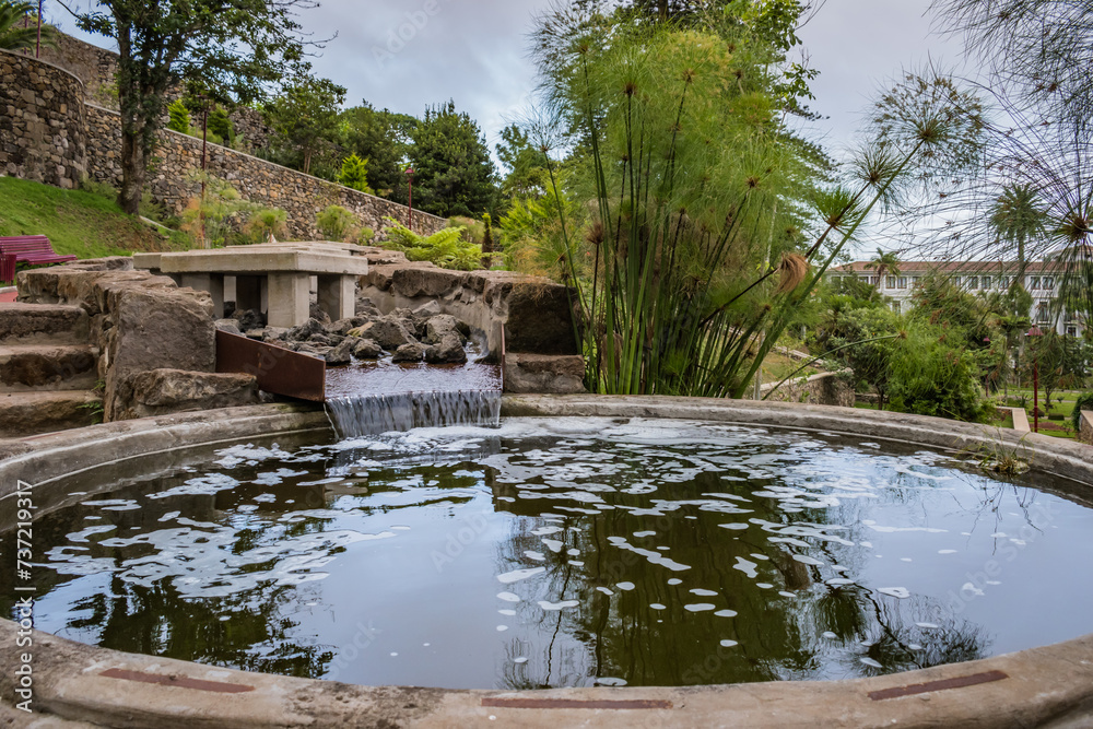 Obraz premium Water flowing to lake with reflection shadows on cloudy day at Duque da Terceira garden, Angra do Heroísmo - Azores PORTUGAL