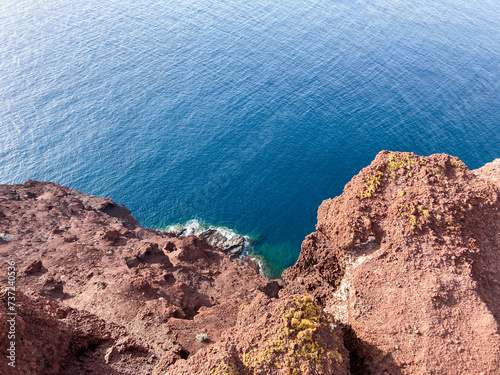 Hiking Montaa Roja in El Mdano, Tenerife. Red volcanic cliff with blue sea. View of the Atlantic photo