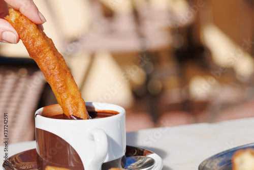 Desayunando churros, porras, con taza de chocolate caliente en El Campello, España photo