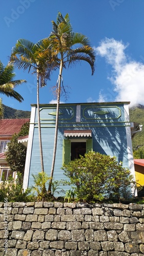 Jolie case créole façade au visage bleu et son ombrelle de palmiers photo