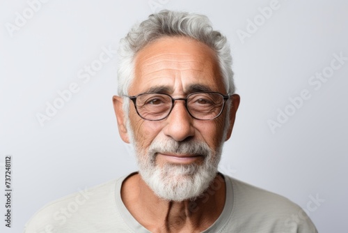 Portrait of a senior man with eyeglasses against grey background