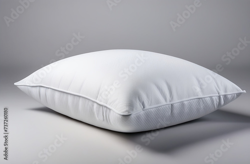 One white pillow separately on a gray background. Side view