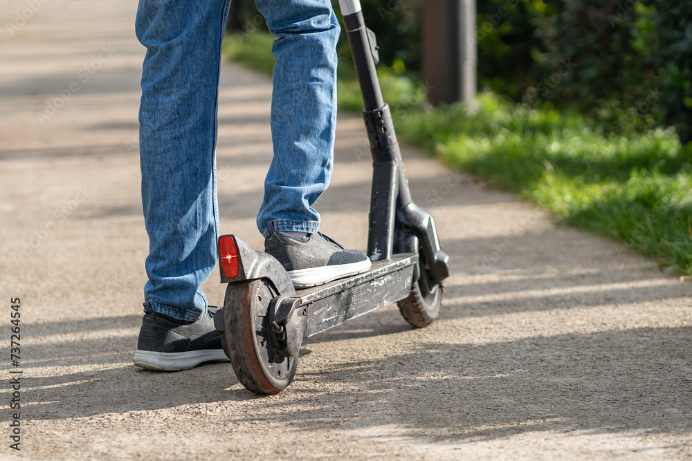Old electric scooter with worn out rubber tyres on wheels, scratched metal components resulting from high speed driving, careless use. E-scooter requiring service, maintenance, repair, replacement Old electric scooter with worn out rubber tyres on wheels, scratched metal components resulting from high speed driving, careless use. E-scooter requiring service, maintenance, repair, replacement