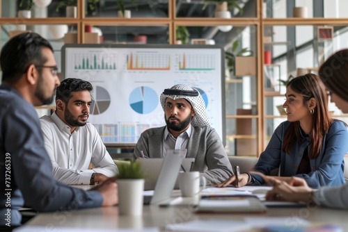 Experience a scene of diversity and collaboration as an Arab investor shares insights with a multi-racial group of colleagues in an upscale office space