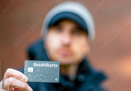 A refugee with a payment card (Bezahlkarte) in Germany. Symbol for the new payment card for refugees in Germany. © Fokussiert