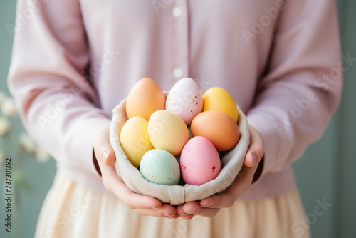 Female hands holding basket of colorful pastel eggs,ai generated