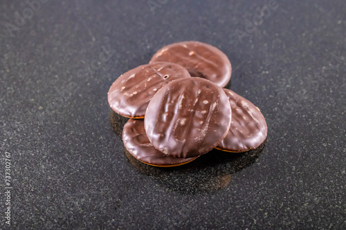 A close up view of chocolate biscuits on a dark marble platter