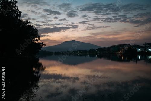 Fototapeta Naklejka Na Ścianę i Meble -  Tranquil Lake Scene at Twilight with Mountain Silhouette