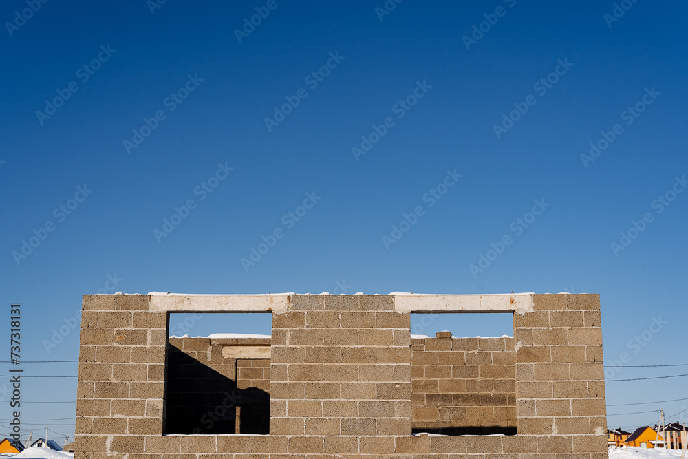 Building under construction with brickwork facade against blue sky Building under construction with brickwork facade against blue sky