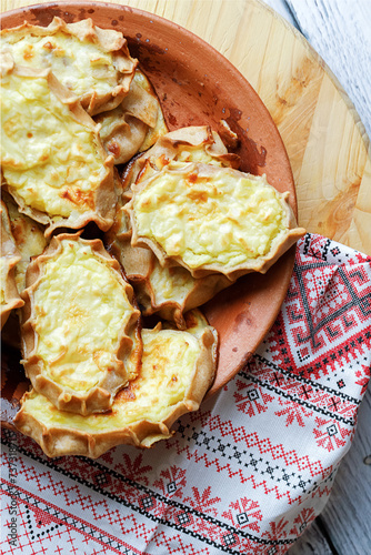 Karelian plays or Karjalanpiirakka. Traditional finnish or north russian pastry on clay plate. Top view. photo