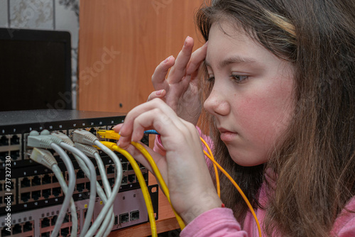 A child connects wires to a network switch. A girl sets up an Internet connection.
