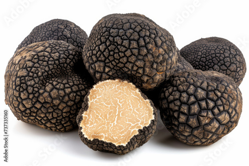 Black truffles, prized delicacies, are showcased against a pristine white background, highlighting their exquisite texture and aroma.