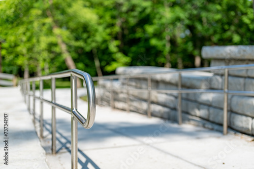 Vászonkép Outdoor, exterior gray concrete ramped sidewalk with stainless steel railings