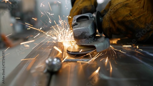 A metal saw close-up on the sides flies with bright sparks from an angle grinder. Hot sparks when grinding steel material. Metal scraping, flying sparks, close-up.  photo
