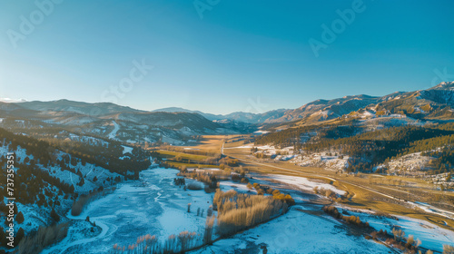 Drone Aerial Shot of Majestic Mountain Landscape Under a Clear Blue Sky with Snow - Beautiful Nature Scenery, Green Valley - Serene Wilderness, Adventure Tourism Concept - High Resolution Stock Image