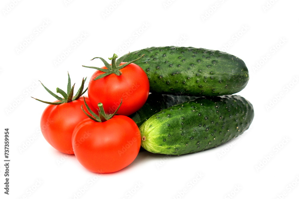 Cucumbers and tomatoes in one pile lie on a white background. Cucumbers and tomatoes in one pile lie on a white background.