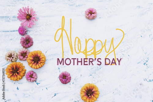 Happy mothers day greeting with zinnia flowers from garden as flat lay background.