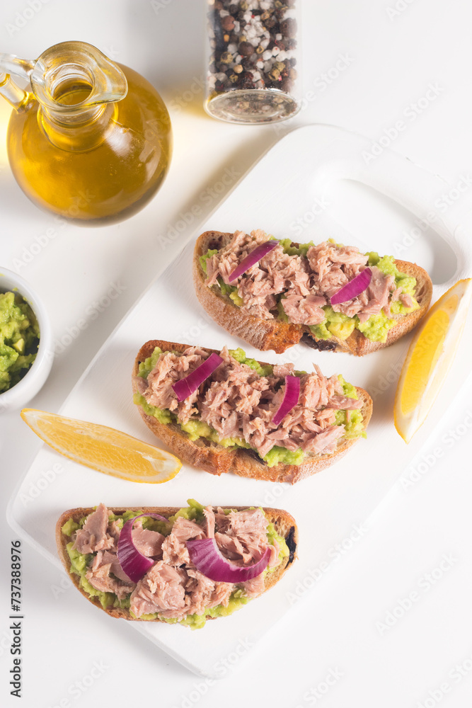 Toast with Canned Tuna. Fish open sandwich with avocado, red onion and lemon. Toast with Canned Tuna. Fish open sandwich with avocado, red onion and lemon.