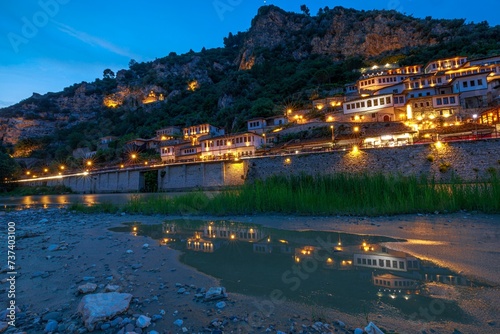 At night in Albania, Berat town looks stunning with its impressive Ottoman architecture towering over the dark sky. It truly captures the beauty and uniqueness of Berat's urban layout. photo