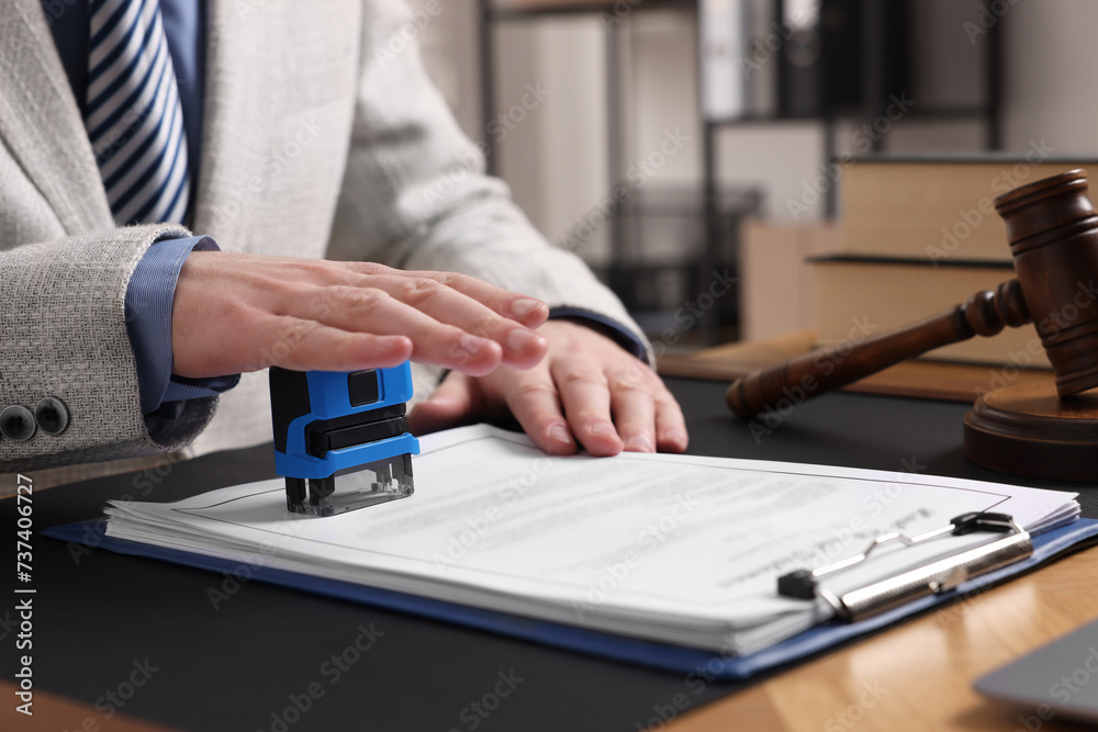 Fototapeta premium Notary stamping document at table in office, closeup