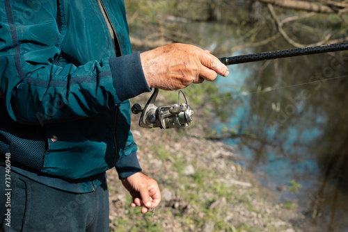 Unrecognized fisherman holding his fishing pole and waiting to catch a fish