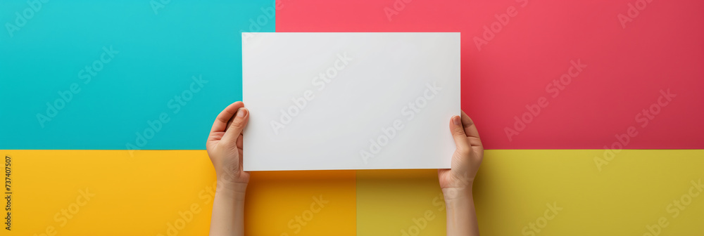 Hand holding rectangular blank white paper card on colorful pastel background. Blank card for advertising mockup, copy space for text. Hand holding rectangular blank white paper card on colorful pastel background. Blank card for advertising mockup, copy space for text.